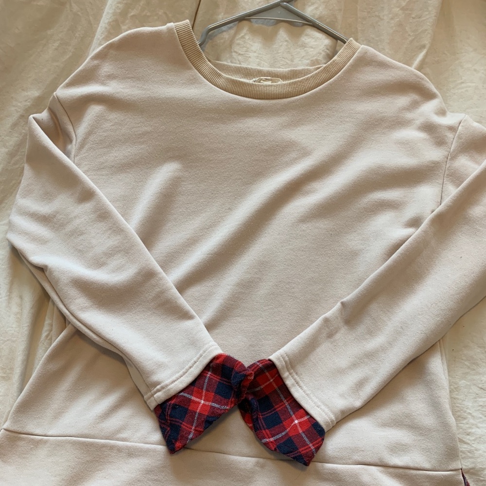 Tan crew neck sweater with plaid underneath